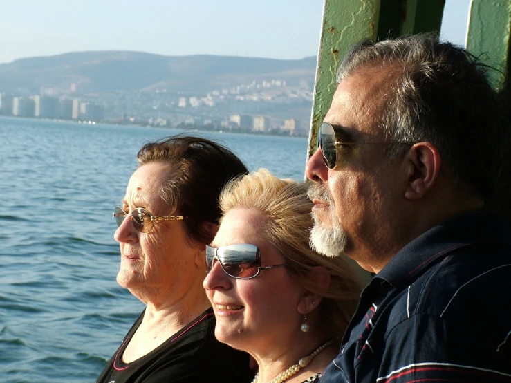 several people sit on a wooden platform overlooking the ocean