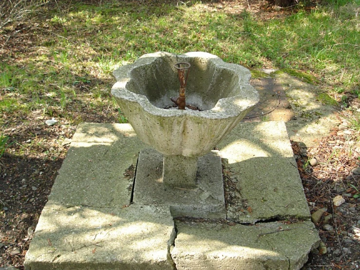 an old stone fountain sits in a park