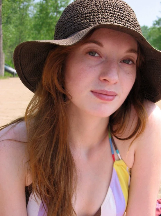 a woman in a sun hat posing for the camera