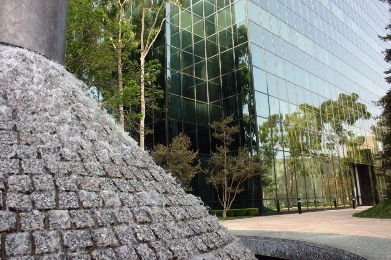 a building that has a glass facade and a stone fountain