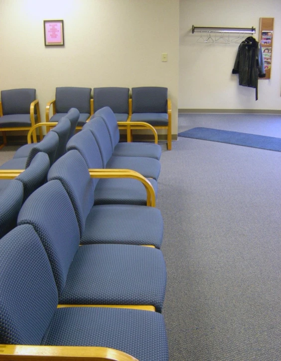 a blue bench and chairs lined up in a small room