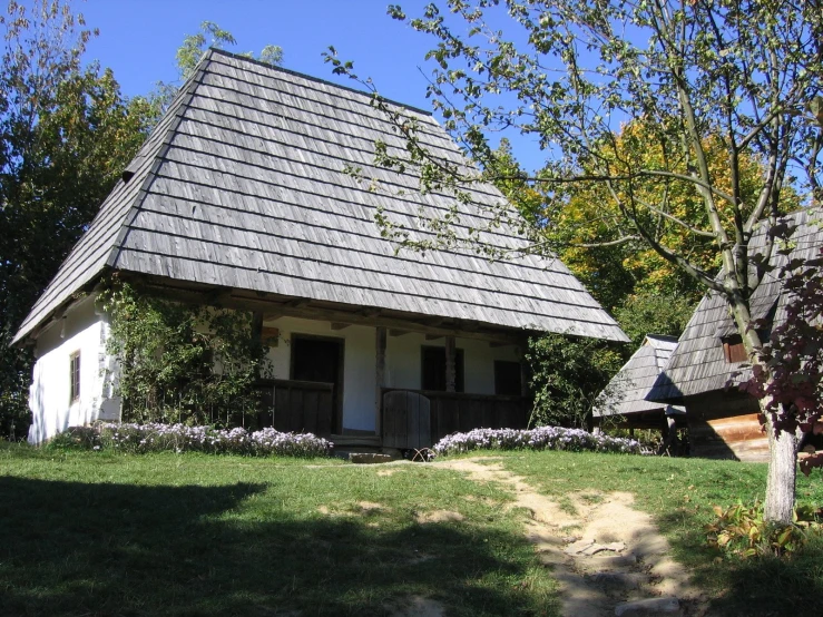 a house with some flowers in front and a pathway to the other side