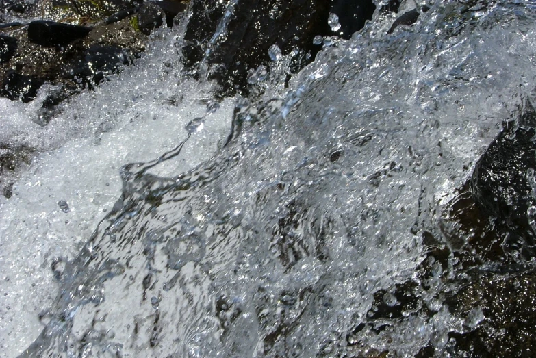 the water is coming out of the river onto rocks