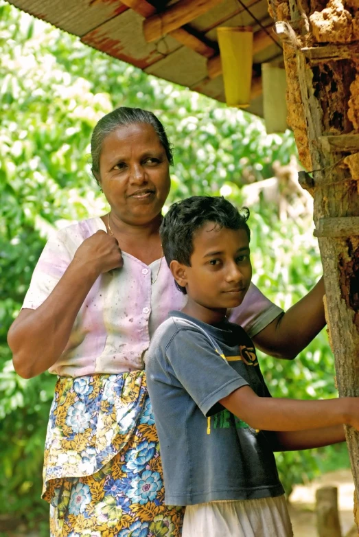 a woman and a boy standing together and posing for the camera