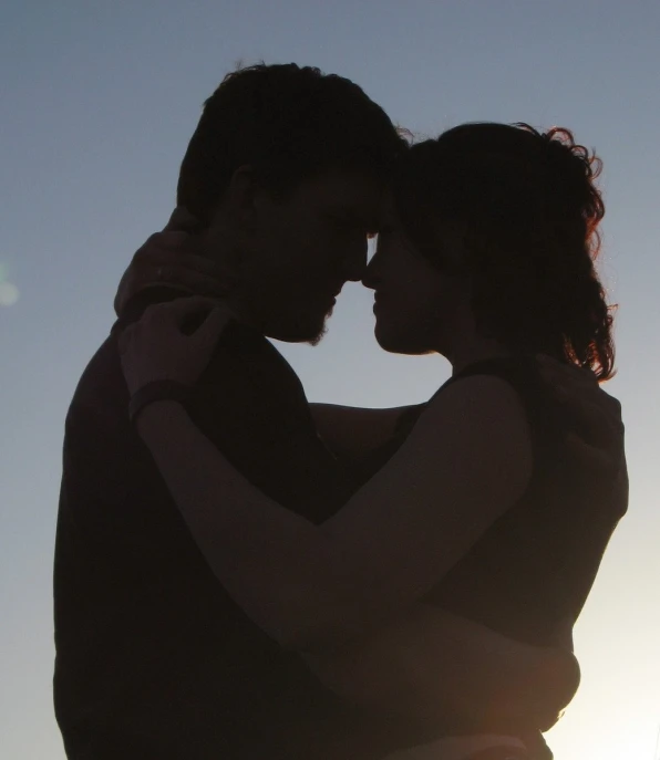 the man is kissing the woman from behind