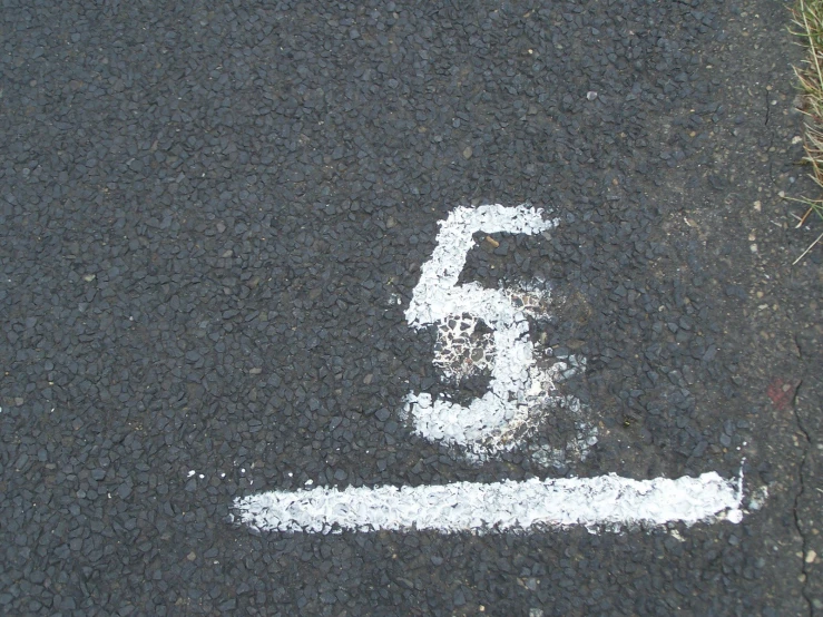 white markings on pavement indicating the number 5