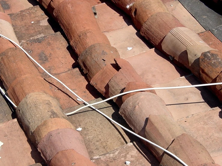 an old red clay roof and chimney pipes with one cord connected