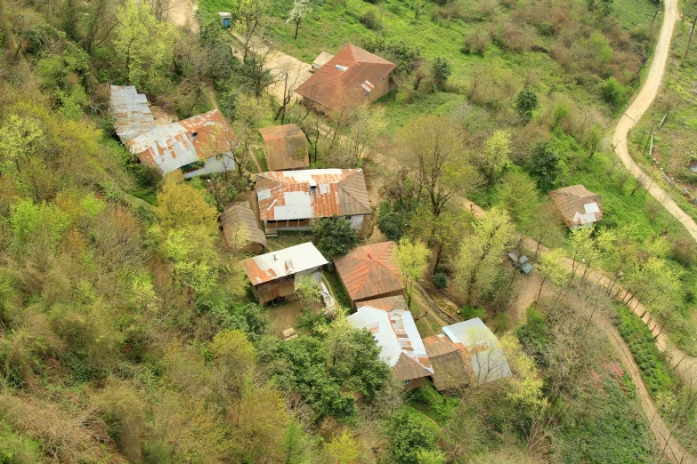 an aerial view of two old farm houses in a field