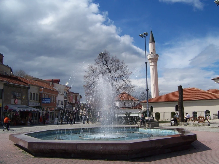 a water fountain on the sidewalk near buildings