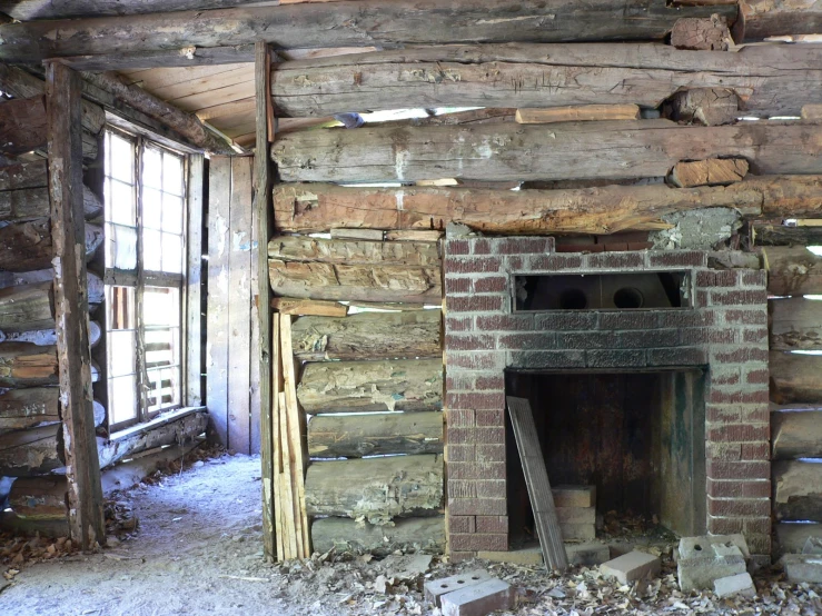 a picture of a fireplace in an old log cabin