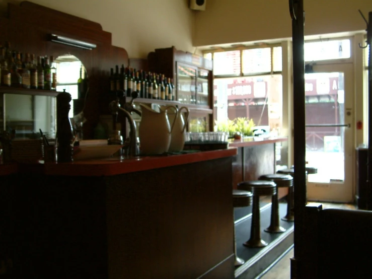 a bar with a bunch of bottles and cups sitting on the bar