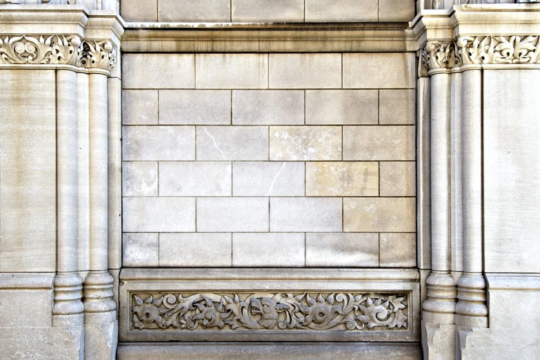 a stone bench sitting in the corner next to a wall