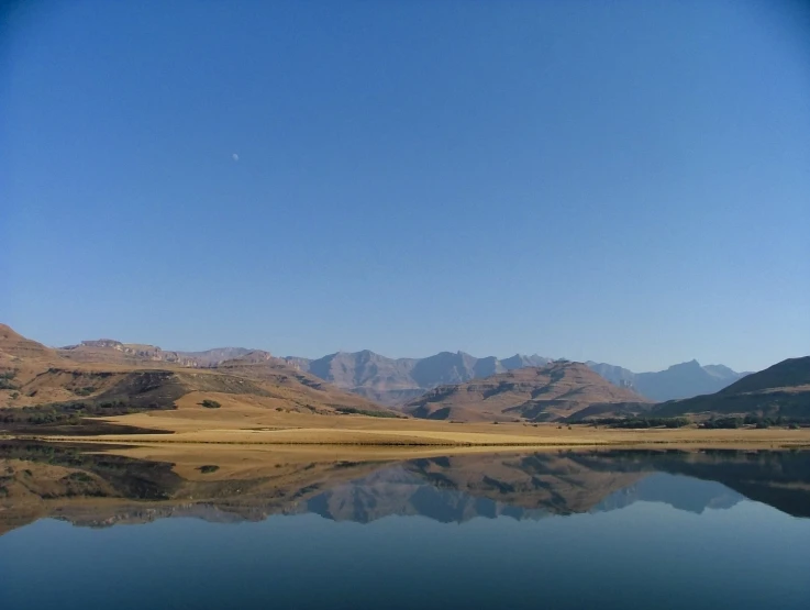 water with mountains and blue sky reflected in the water