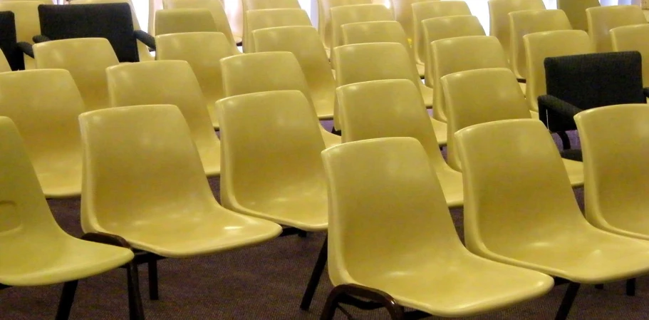 rows of yellow plastic chairs in the large room