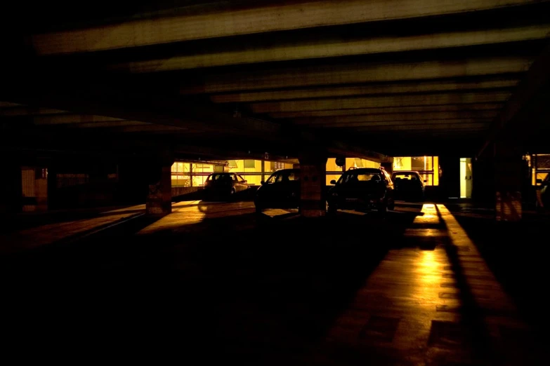 a dark parking lot with some parked cars at night