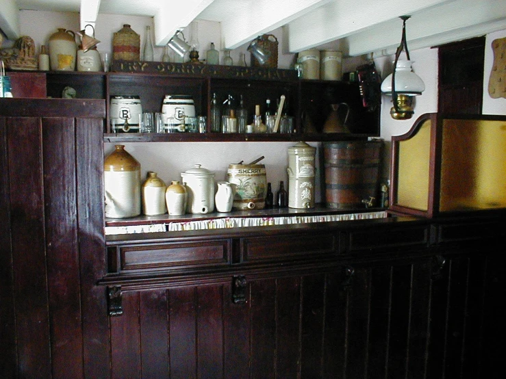 an old - fashioned kitchen has lots of bottles and jugs