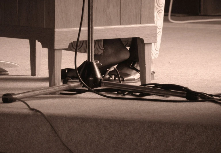 someone is playing wii underneath the table in black and white