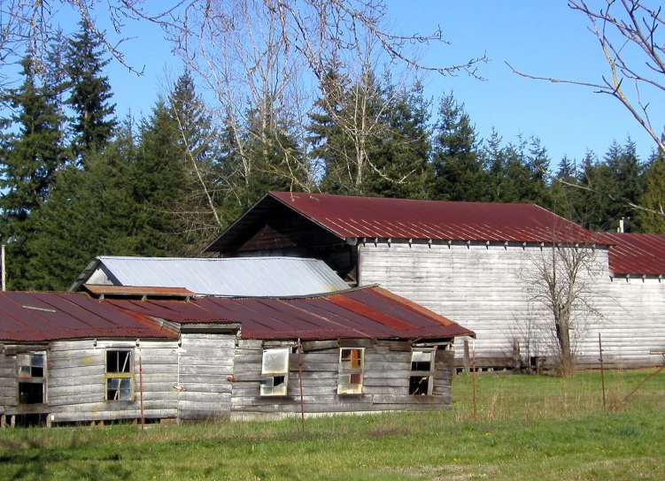 a large building sitting in a grass field near trees