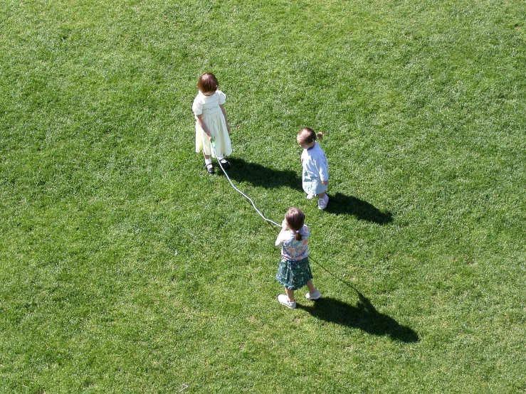 a child and an adult stand in a field of grass