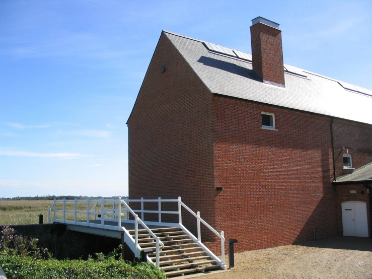 a large red brick building with two white stairs next to it