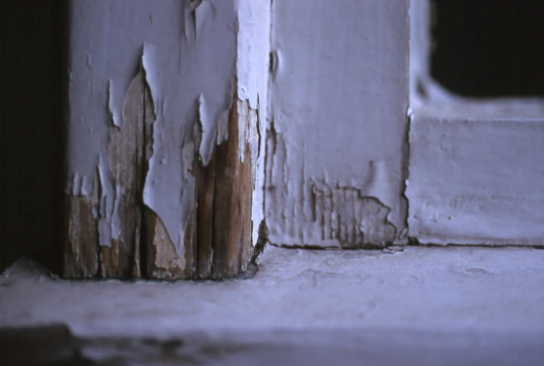 peeling paint on wood panels inside a room