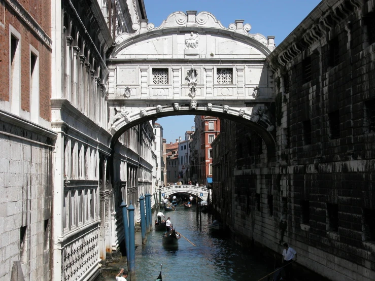 a canal runs beneath a bridge between two buildings