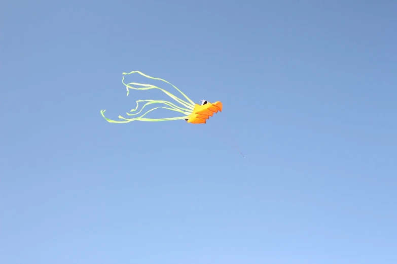 a large kite is flying in the clear blue sky