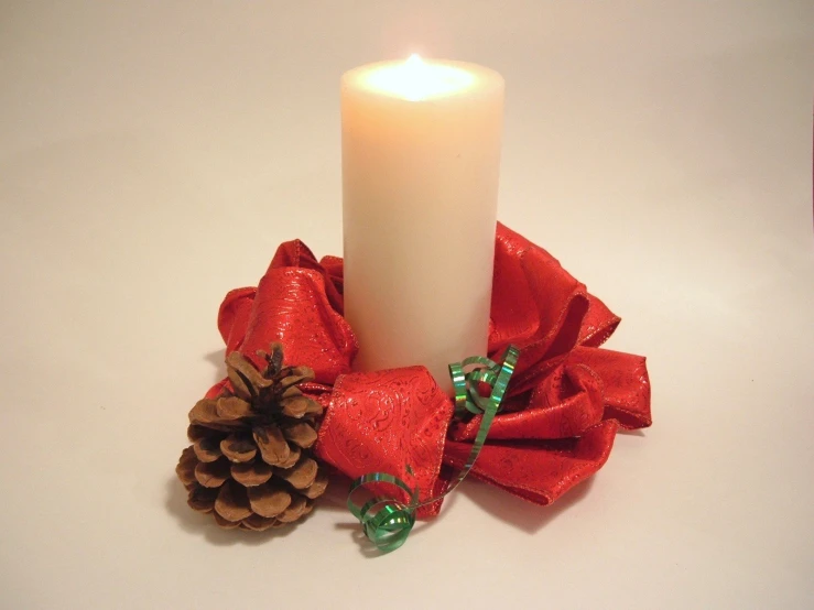 the christmas candle is decorated with decorations on the table