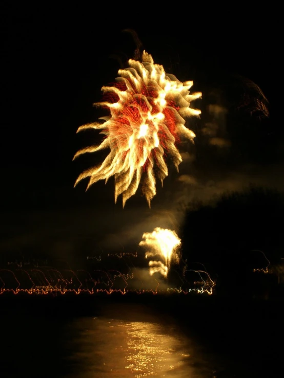 a colorful fireworks is lit up with the dark sky