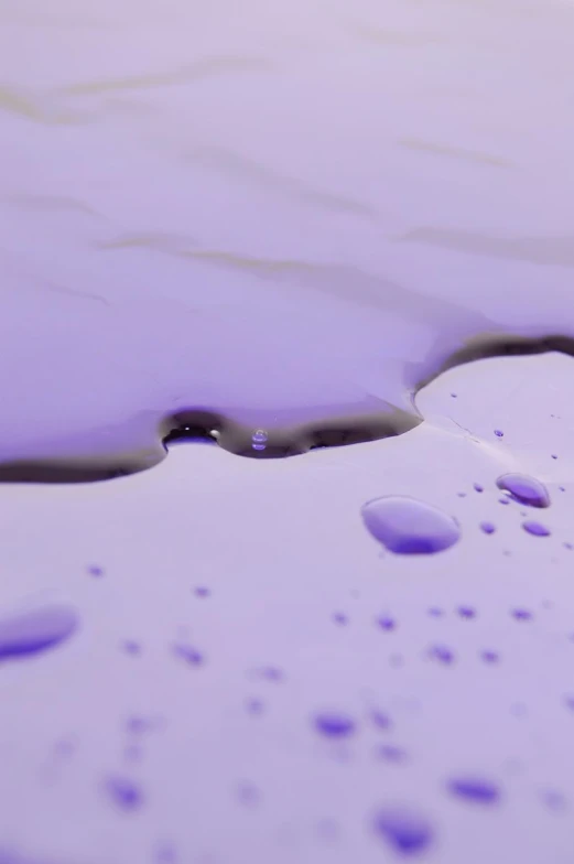 drops of water on the surface of purple paint