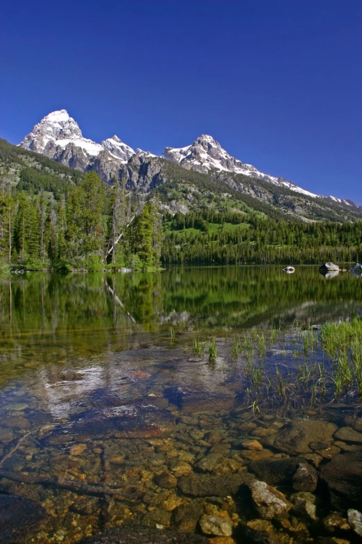 the mountains are reflected in the still water of a lake