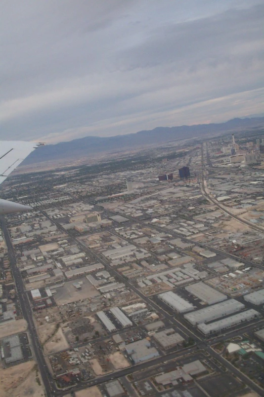 an airplane flies over a city and mountains