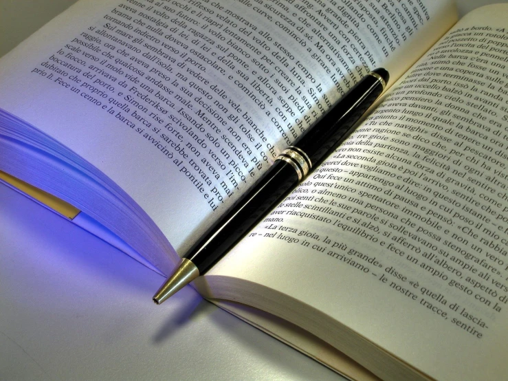an open book with a pen and stylus