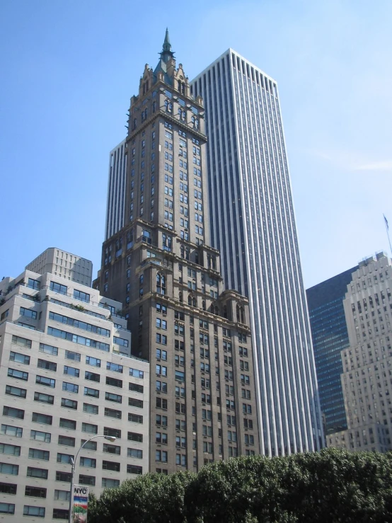 tall buildings are shown near one another with a blue sky in the background