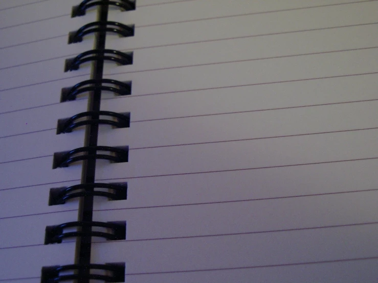 a spiral bound notebook with black lines