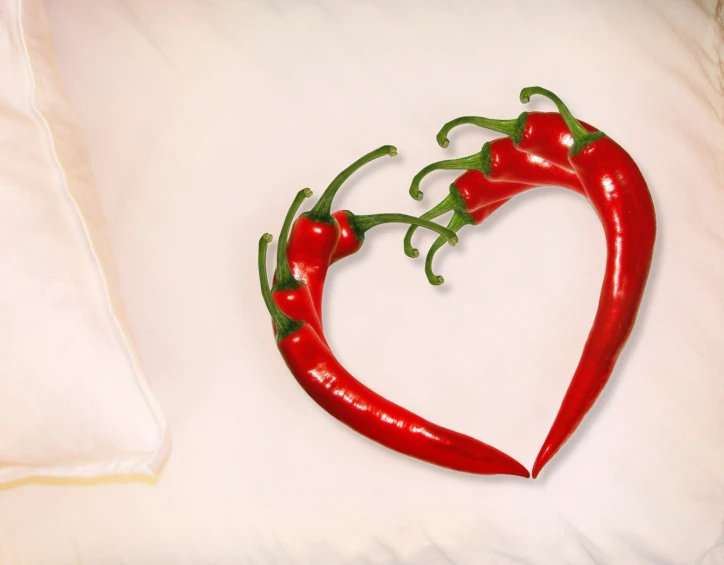 a couple of peppers are arranged into a heart