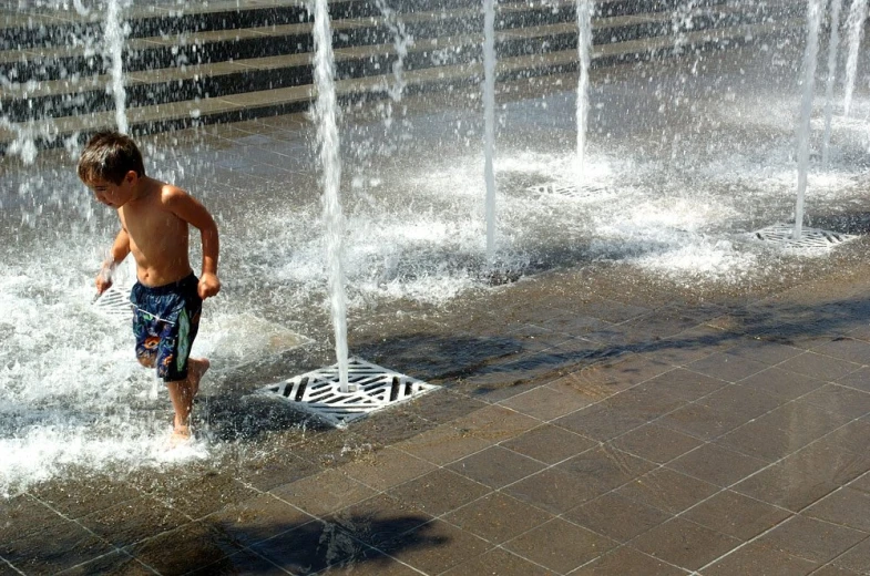 a  is playing in a water fountain