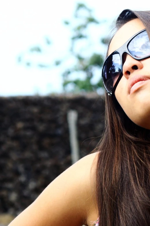 a woman wearing sunglasses while talking on the phone