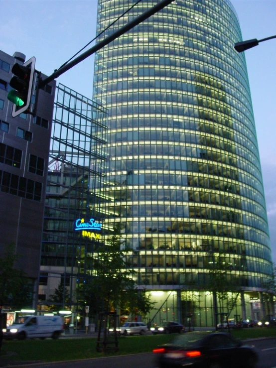 a street scene of a city building with cars coming by