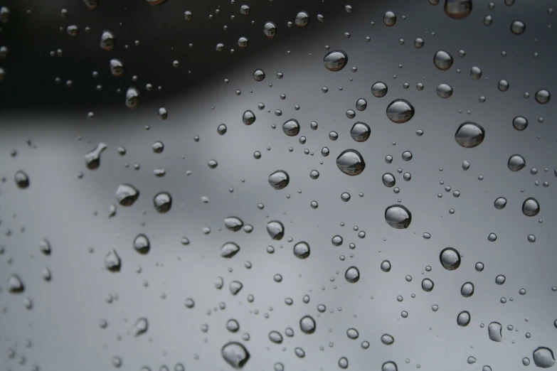 droplets of water on a window pane with dark clouds in the background