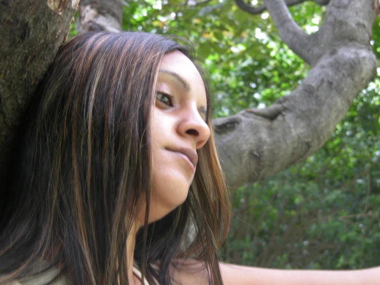 a close up of a person holding a cell phone near trees