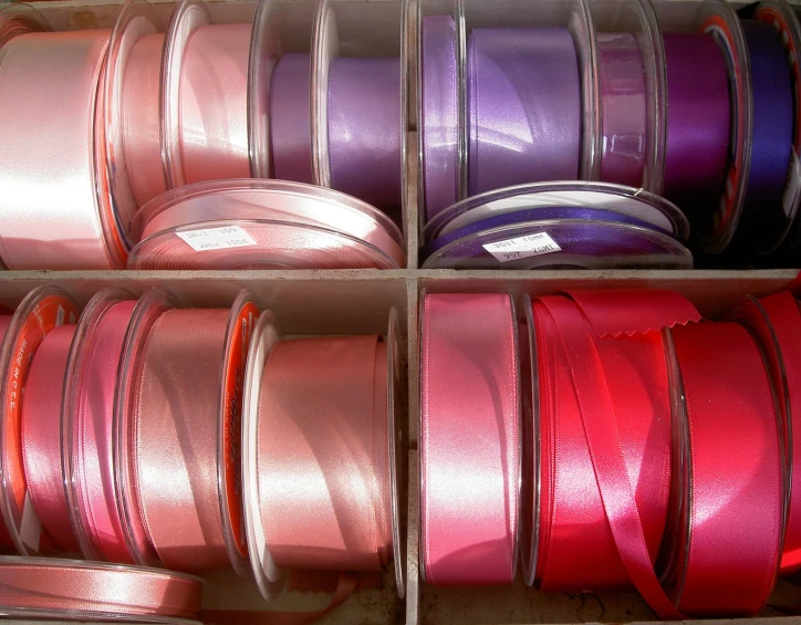 a pair of boxes filled with assorted spools of ribbon