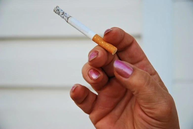 a person holding a cigarette with one end in their hand