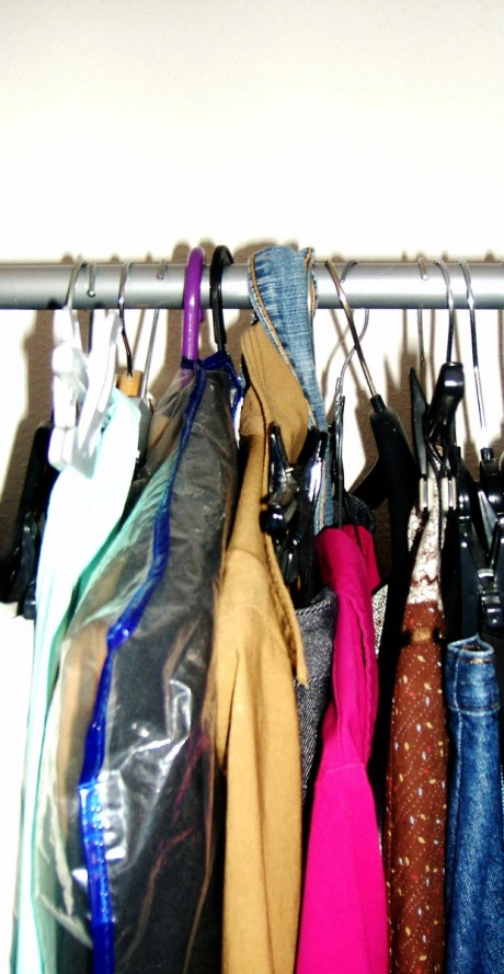 various colored clothes hanging on rack with hooks