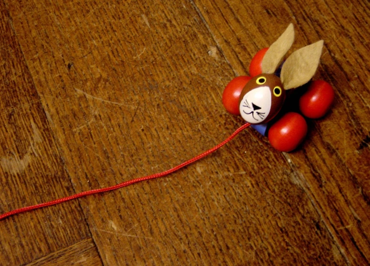 a wooden table with a red string, some decorations and another toy on top of it