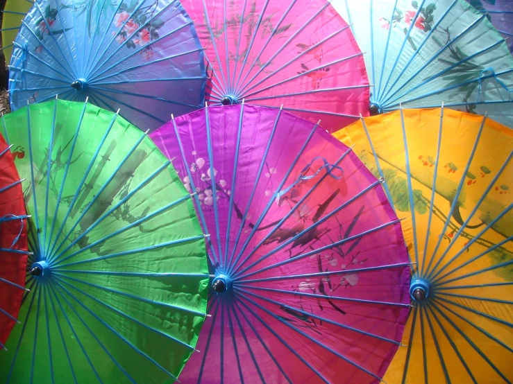 many multicolored umbrellas sit in the sun