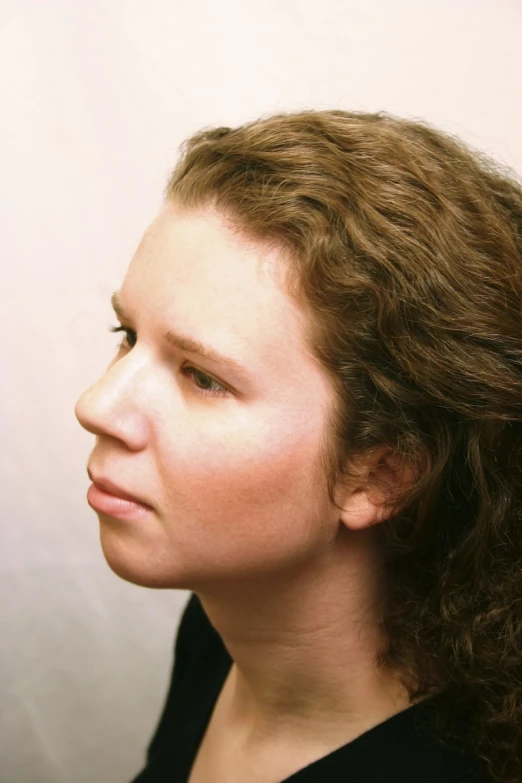 a woman is showing her face while wearing a black shirt