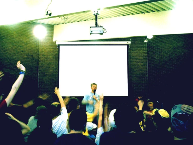 a group of people raising their arms up to speak