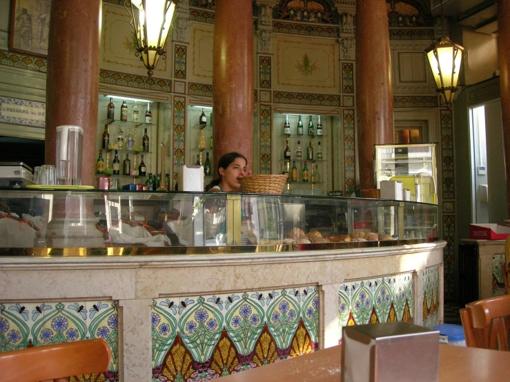 a man is standing in a restaurant behind the counter