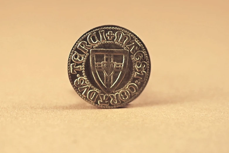 a small gold and black badge with the word college on it
